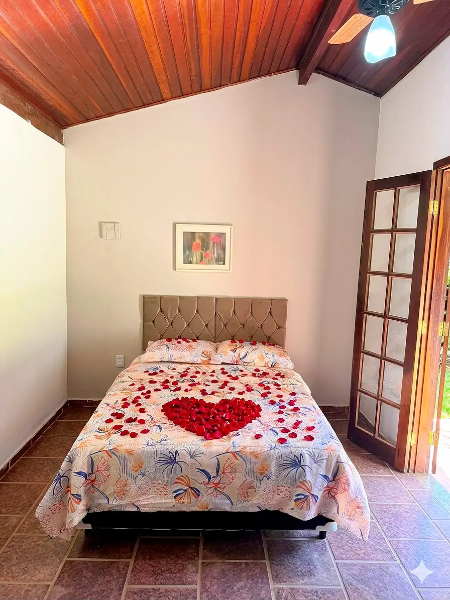 Suíte de casal decorada com coração de pétalas na cama